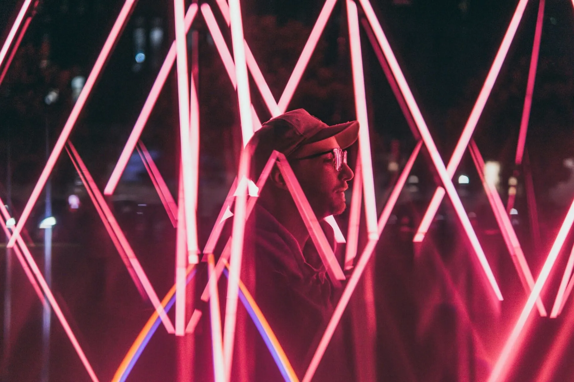 man standing between neon lights